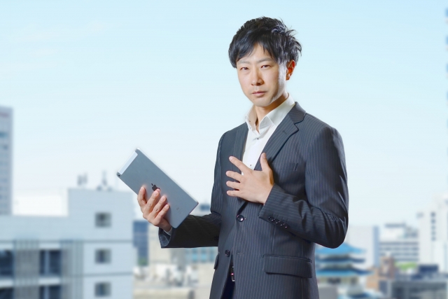 都市を背景に考える男性ビジネスマン